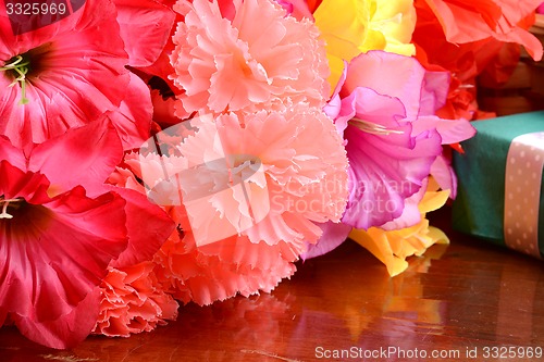 Image of present gift box and flower bouquet on silk