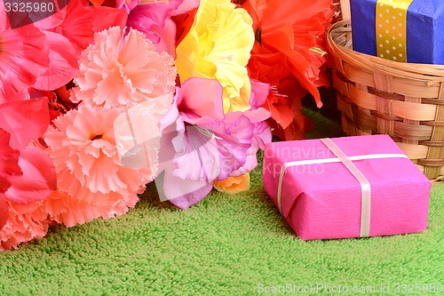 Image of present gift box and flower bouquet on silk