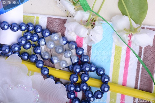 Image of Office table with flower, ribbons, pencils, pearls