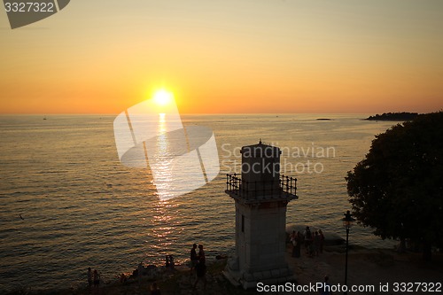 Image of Tourists watching sunset on Adriatic coast