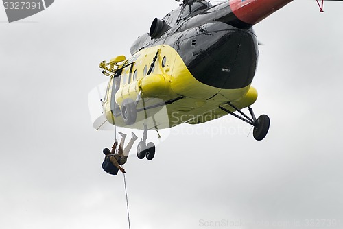 Image of Rescuer is landed from MI-8 helicopter by rope