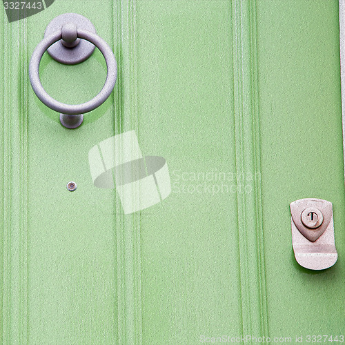 Image of green  handle in london antique brown door  rusty  brass nail an