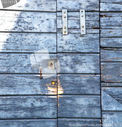 Image of abstract cross santo   brass brown   wood door   varese italy