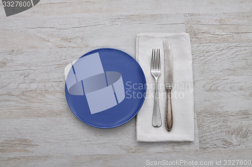 Image of Plate, cutlery and cloth on wood