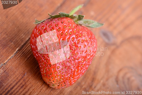Image of Strawberry on wooden plate close up