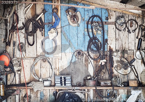 Image of old tools hanging on wooden wall