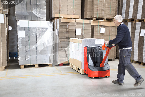 Image of Worker Pushing Stock On Handtruck