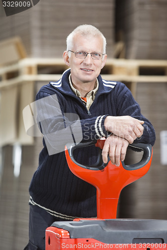 Image of Confident Worker Leaning On Handtruck