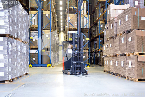 Image of Worker In Forklift Examining Stock