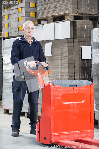 Image of Worker Standing With Handtruck At Warehouse