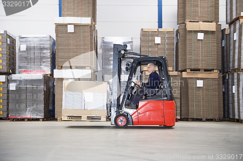 Image of Supervisor Driving Forklift In Warehouse