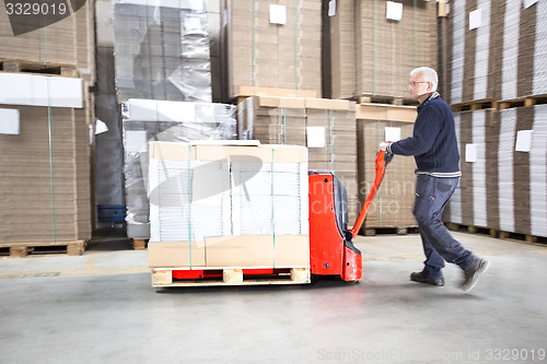 Image of Worker Transporting Goods On Handtruck