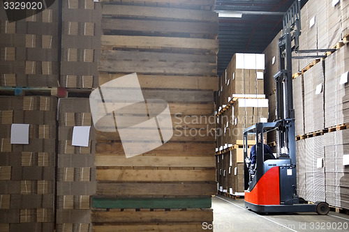 Image of Man In Forklift Examining Stock