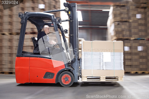 Image of Worker Transporting Stock On Forklift