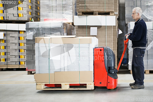 Image of Worker With Loaded Handtruck In Warehouse