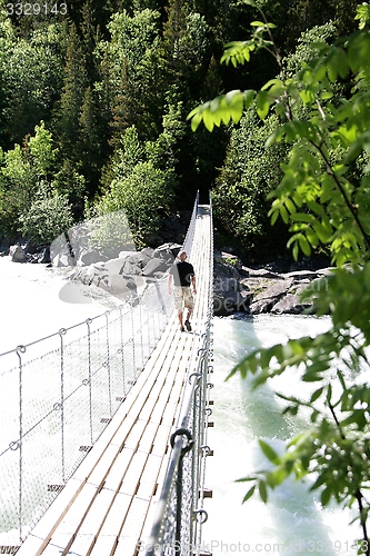 Image of Man on suspension bridge