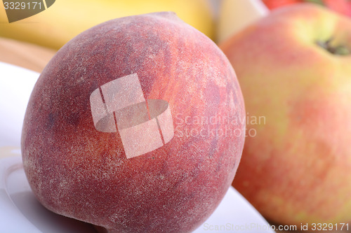 Image of peach,  apple and strawberry on wooden plate 