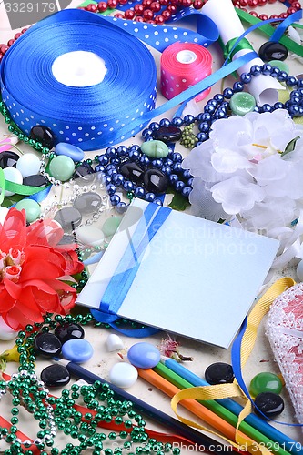 Image of Office table with flower, blank notepad and colorful pencils