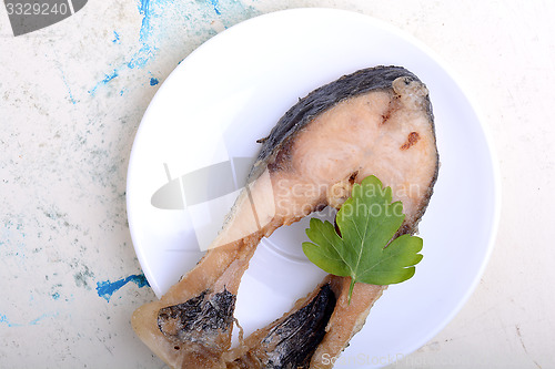 Image of Frying pan with one roasted salmon steaks, view from above