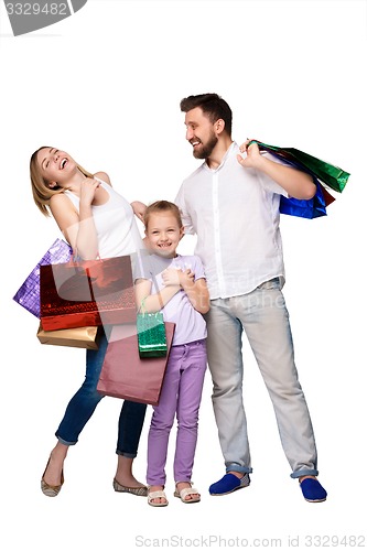 Image of Happy family with shopping bags standing at studio 