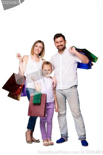 Image of Happy family with shopping bags standing at studio 