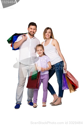 Image of Happy family with shopping bags standing at studio 