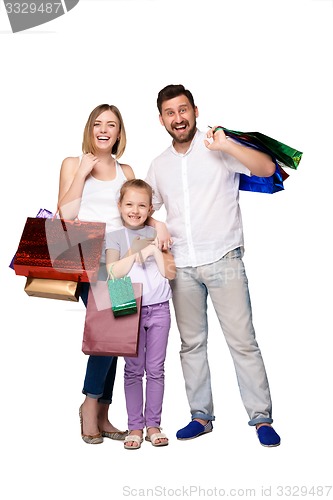 Image of Happy family with shopping bags standing at studio 