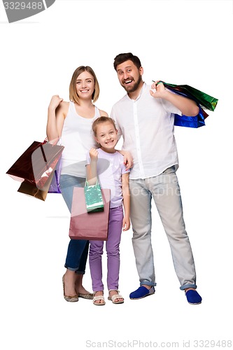 Image of Happy family with shopping bags standing at studio 