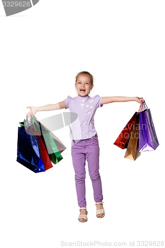 Image of Happy girl with shopping bags standing at studio 