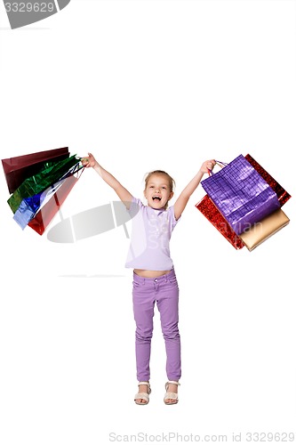 Image of Happy girl with shopping bags standing at studio 