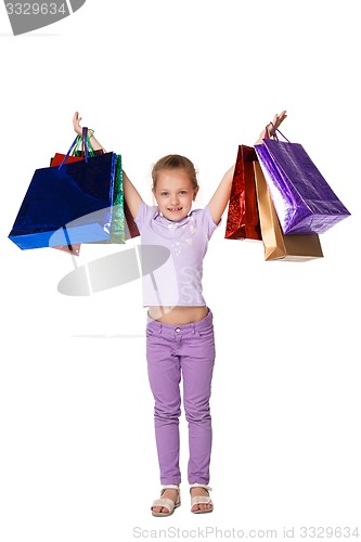 Image of Happy girl with shopping bags standing at studio 