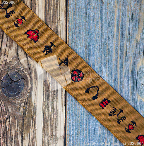 Image of vintage brown tape with embroidered ornaments