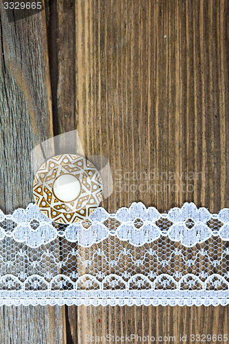 Image of one vintage button and lace tape