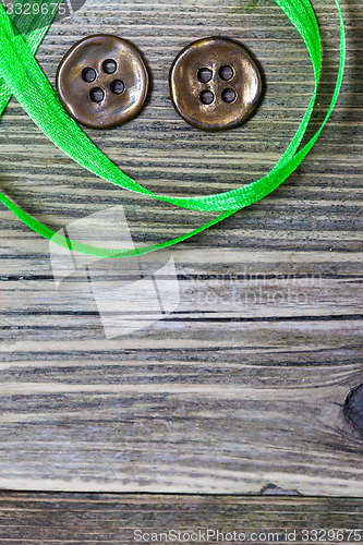 Image of still life with old green tape and two vintage buttons