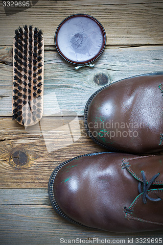 Image of brown boots, shoe polish and shoe brush