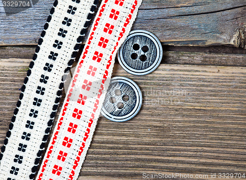 Image of two old ribbons with embroidered ornaments and vintage buttons