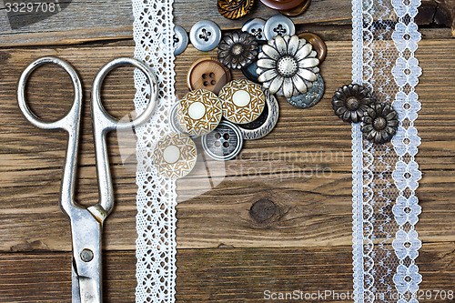 Image of antique lace, buttons and a tailor scissors