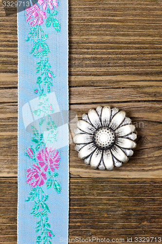 Image of vintage aqua color tape with embroidered ornaments and old butto