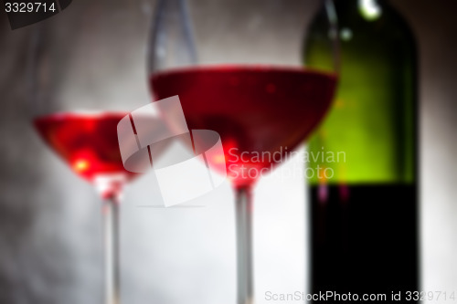 Image of red wine in two goblets and bottle