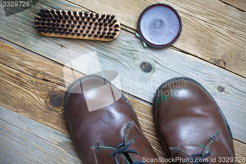 Image of Still life with brown boots, shoe polish and brush