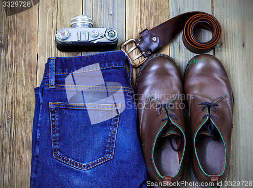 Image of Still life with rangefinder camera, brown boots, leather belt an