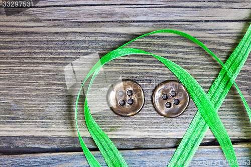 Image of still life with old green tape and two vintage buttons