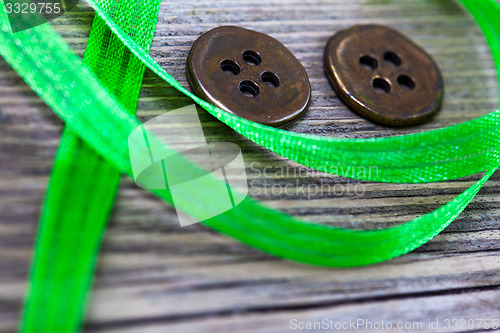 Image of still life with old green tape and two vintage buttons