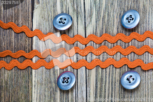 Image of four vintage buttons and old band