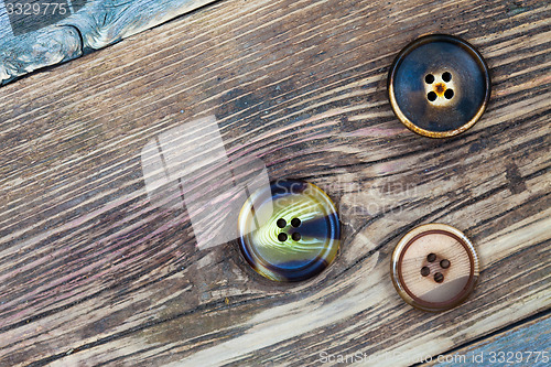 Image of three aged buttons