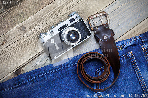 Image of old blue jeans, vintage leather belt and ancient rangefinder cam