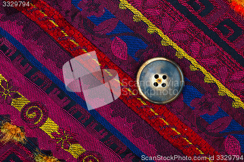 Image of vintage tape with embroidered ornaments and old button