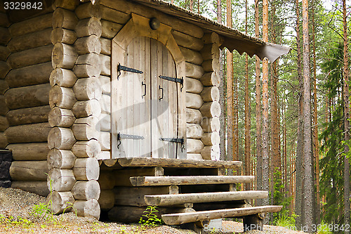 Image of Entrance door and porch of log house in forest