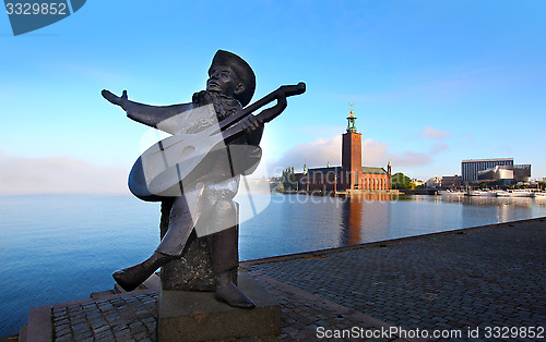 Image of Evert Taube statue with the City Hall in the background