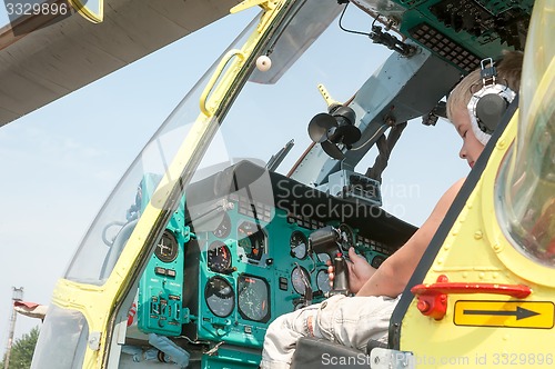 Image of Little boy sitting in cabin of the MI-8 helicopter